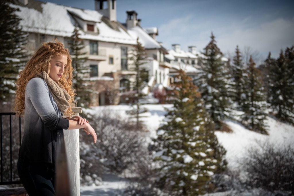 A woman looking out at the scenery from a balcony at All Points North Lodge.