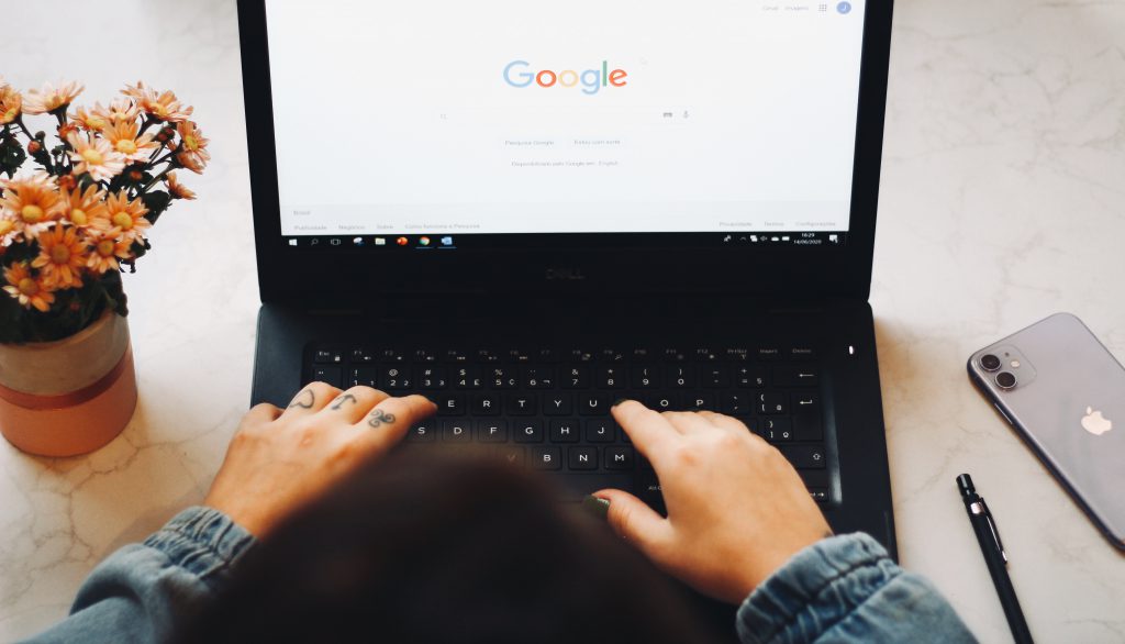 Someone sits at a laptop with Google loaded on the screen, ready to research.