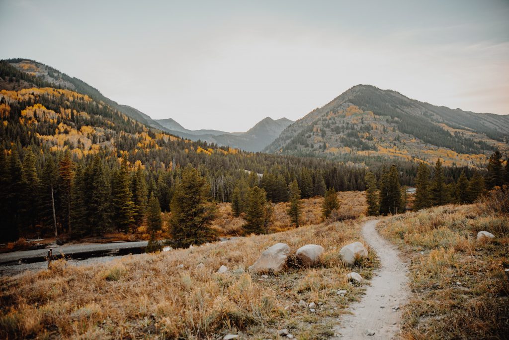 A path weaves toward the Colorado mountains in the distance.