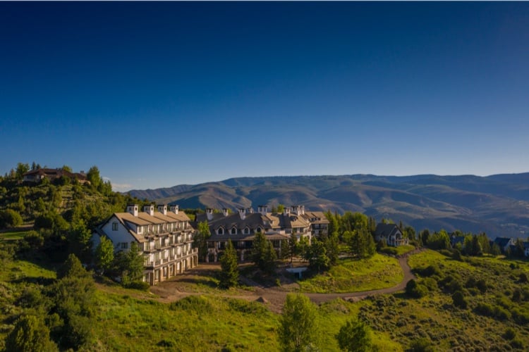 Aerial view of the All Points North Lodge, surrounded by forest-covered mountains