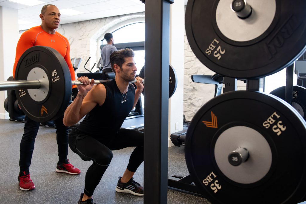 A man squats weight at the APN Lodge gym.