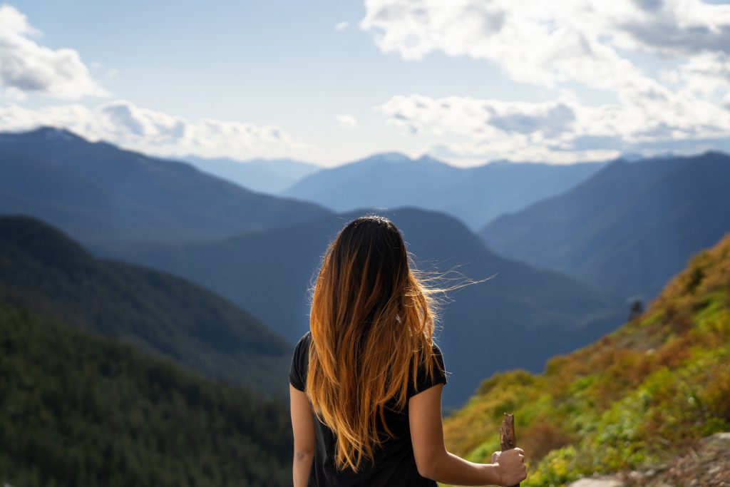 A woman looks out on a mountain range.