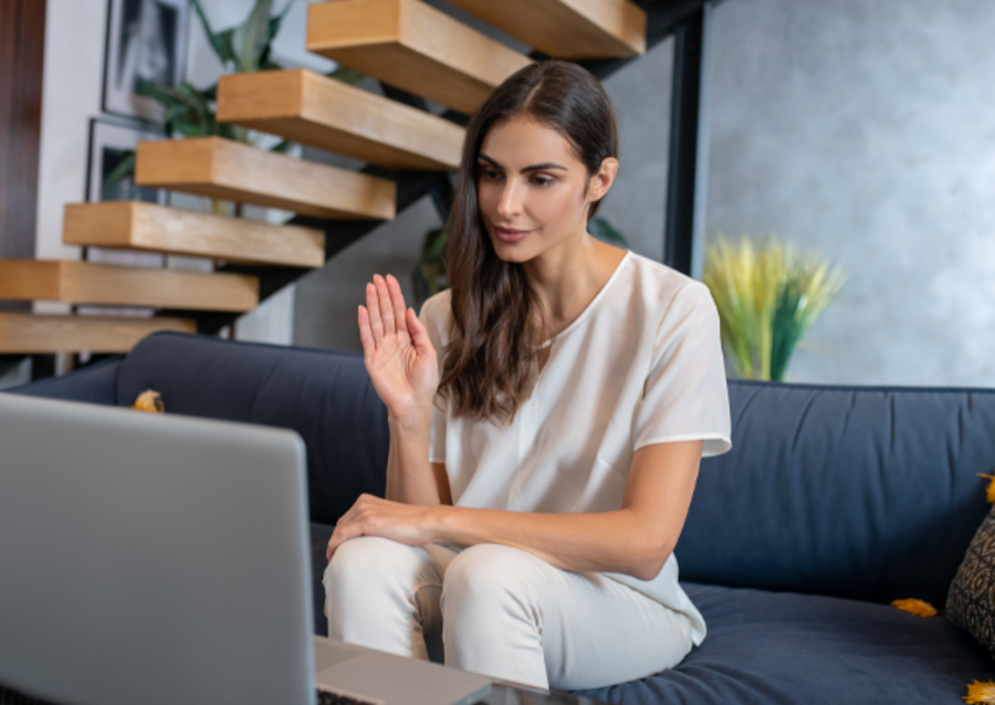 woman waving hello on a computer therapy session