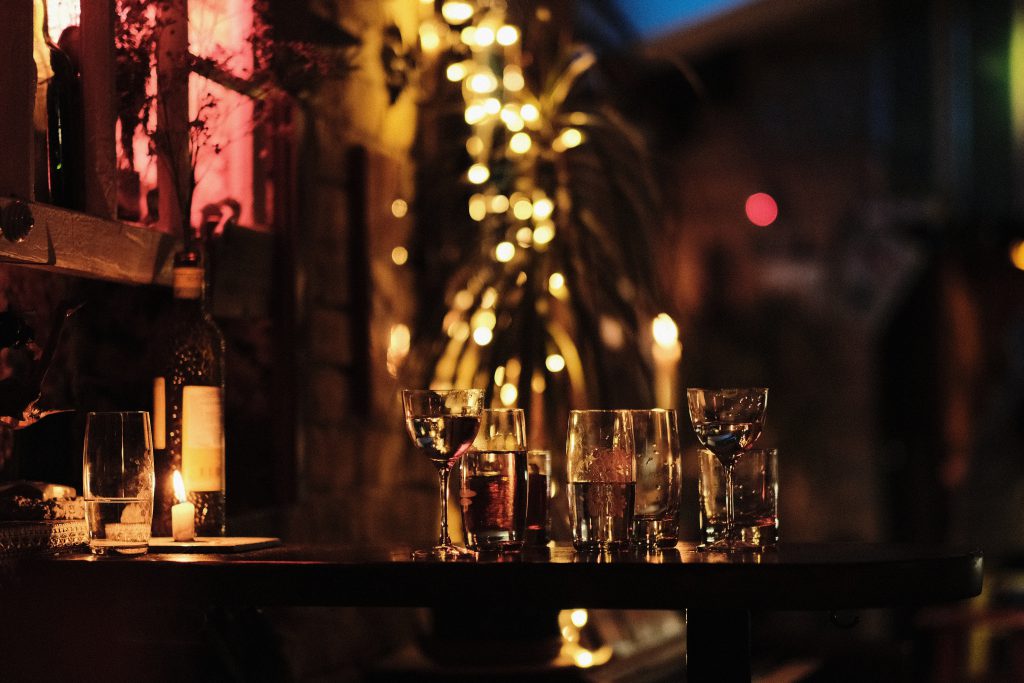 A dimly lit bar with partially full glasses.