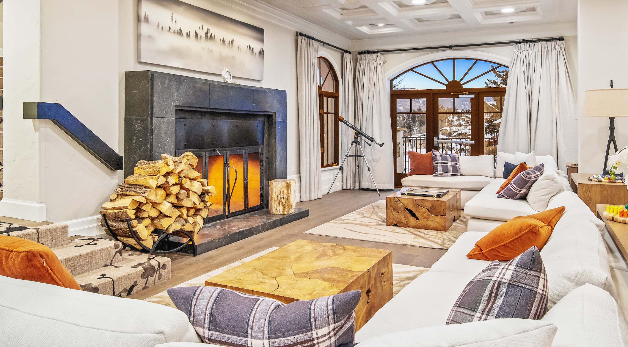 Spacious lobby with couches, tall windows, and large fireplace