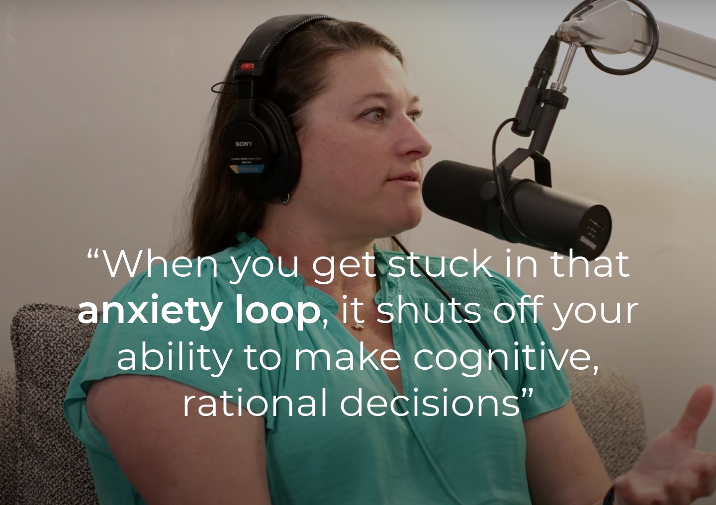 Joanna Kluender speaking into a podcast microphone with a text overlay: