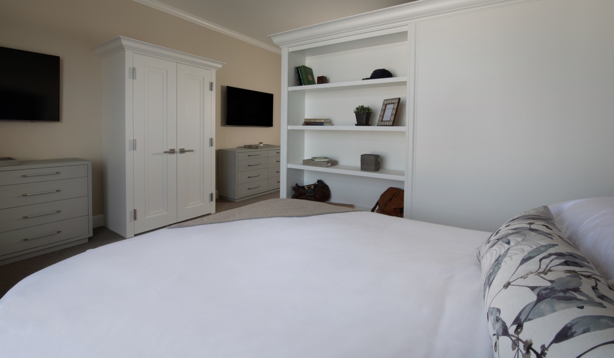 Bed near bookcase and tv