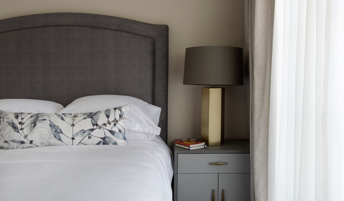 Nightstand with lamp next to a bed