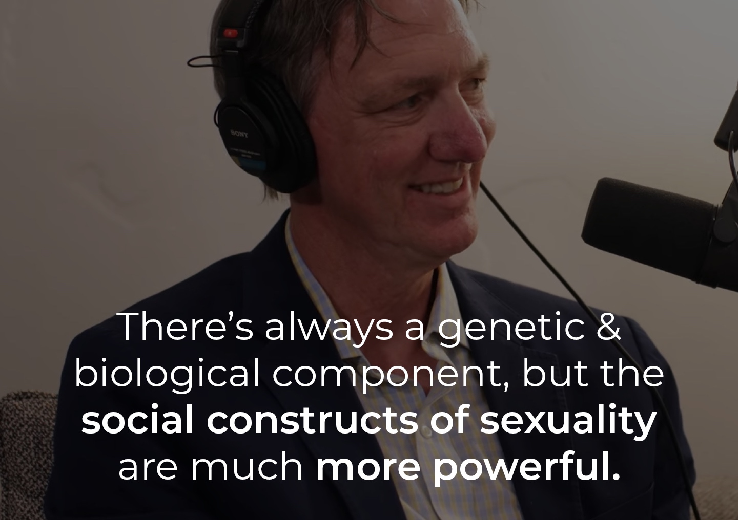 Dr. Philip Hemphill speaking into a podcast microphone with a text overlay: There's always a genetic and biological component, but the social constructs of sexuality are much more powerful.