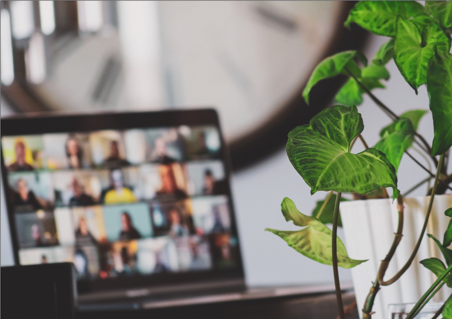 A laptop with a virtual meeting room full of participants.