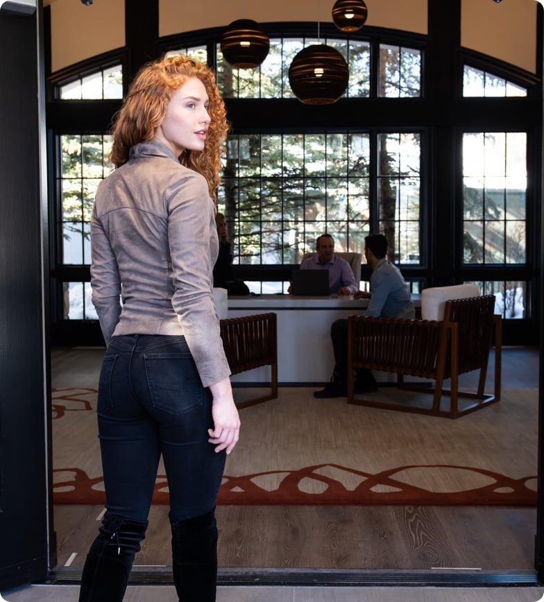 Woman looking back as she enters the All Points North Lodge entryway