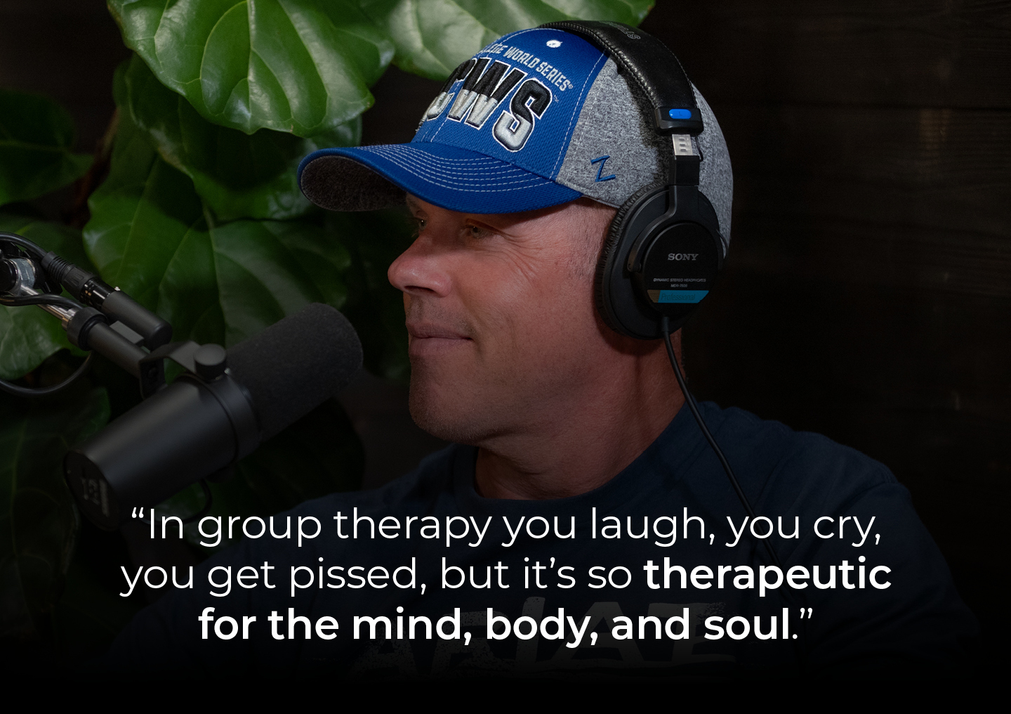 Dave speaking into a podcast microphone with a text overlay: In group therapy you laugh, you cry, you get pissed, but it’s so therapeutic for the mind, body, and soul.