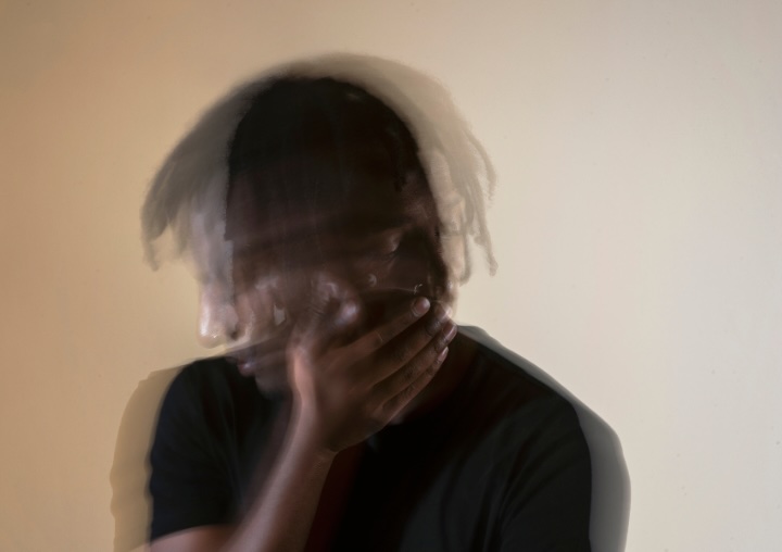 A blurred image of a man shaking his head.