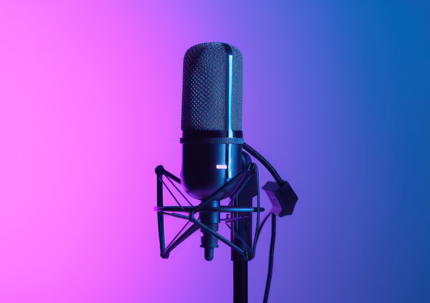 A podcast microphone with an ombre background fading from pink to blue.