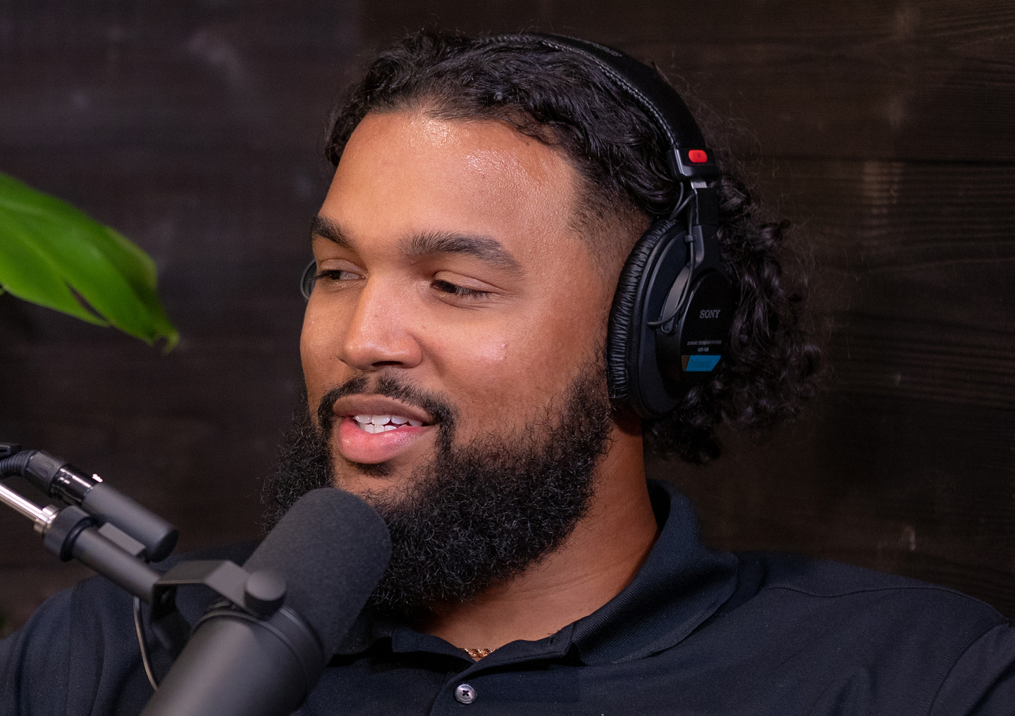 Marcus Smith II talks into a microphone on the Tackling Stigma podcast miniseries.