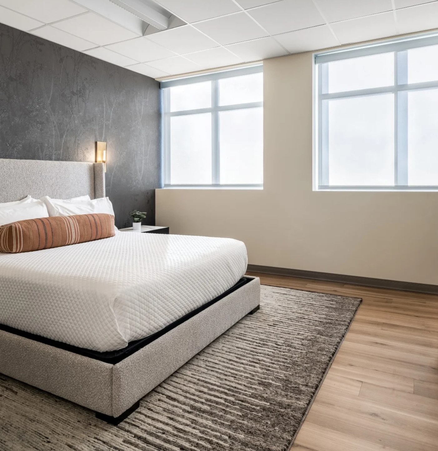 Residential room at APN Dallas-Fort Worth: natural light streams into an airy client room with a large memory foam bed and fitted sheets.