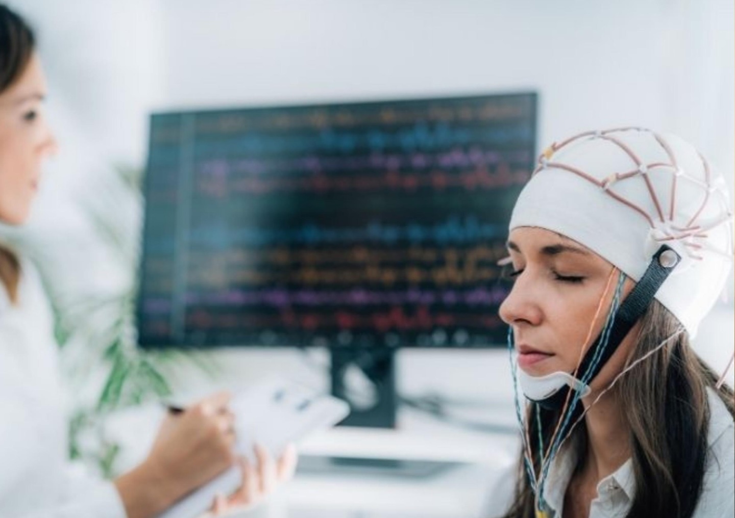 A client completes a neurofeedback and qEEG session at Plus by APN while wearing a neurofeedback helmet.