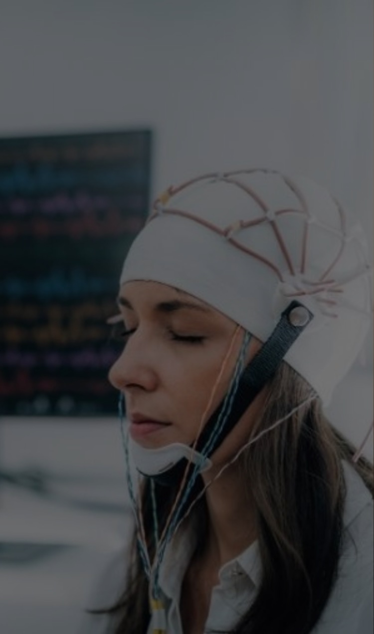 A client completes a neurofeedback and qEEG session at Plus by APN while wearing a neurofeedback helmet.