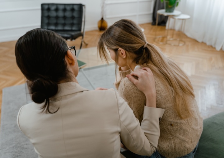 A therapist comforts a client during trauma therapy.