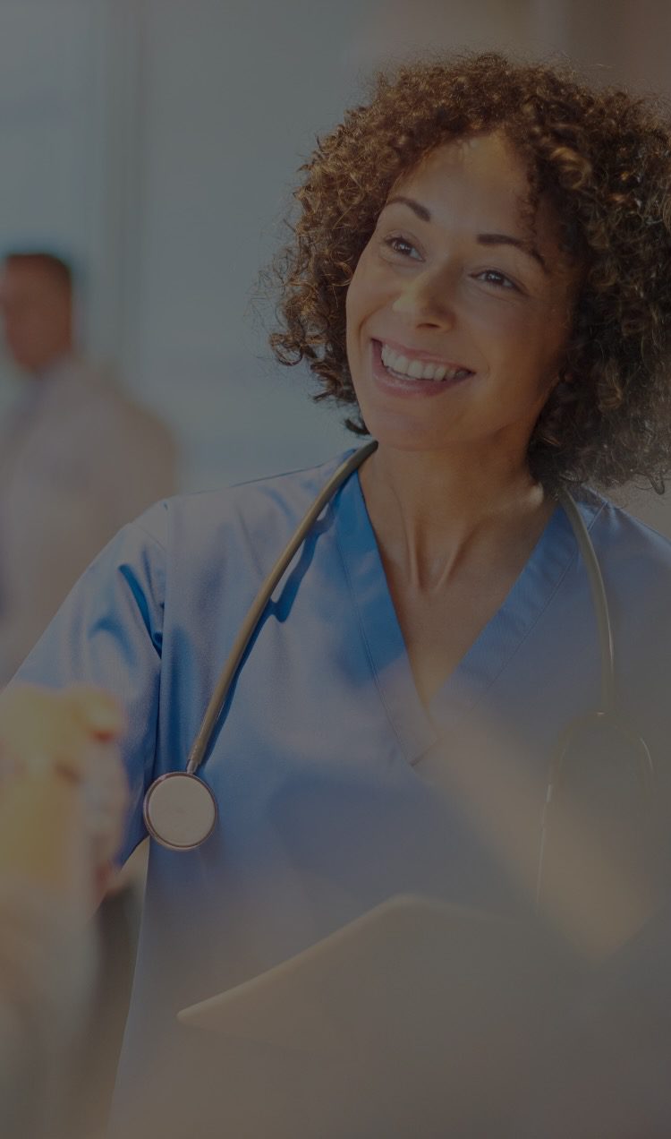 A smiling doctor shakes hands with a patient.